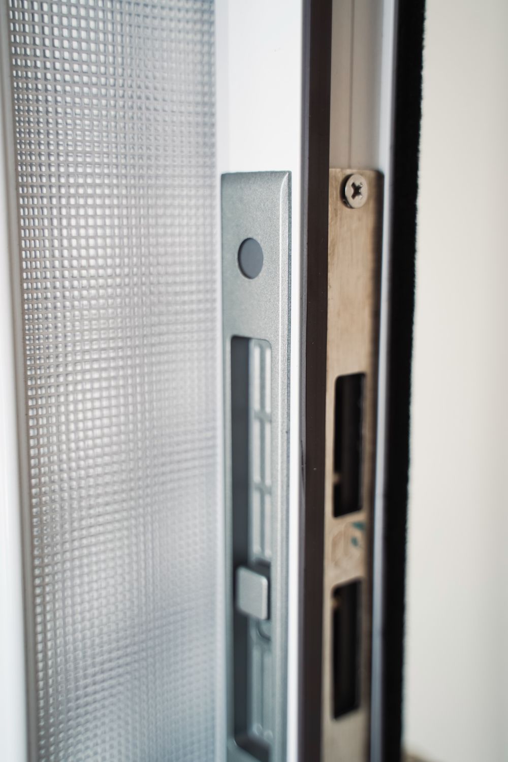 Close-up of the screen's latch and keeper on the door frame