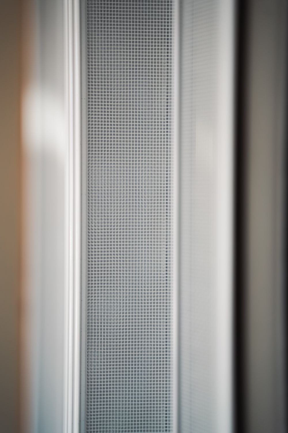 Close-up of a slim white pleat strip and the mesh beside it